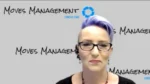 Woman with short purple hair and glasses speaking on camera against a Moves Management backdrop for a consulting video.