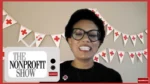 Smiling woman with short dark hair and glasses on a video call, red-and-white Red Cross banners in the background and a 'The Nonprofit Show' graphic on screen.