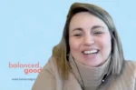 Smiling woman on a video call with a light blue background and a 'balanced good' logo visible on the left.
